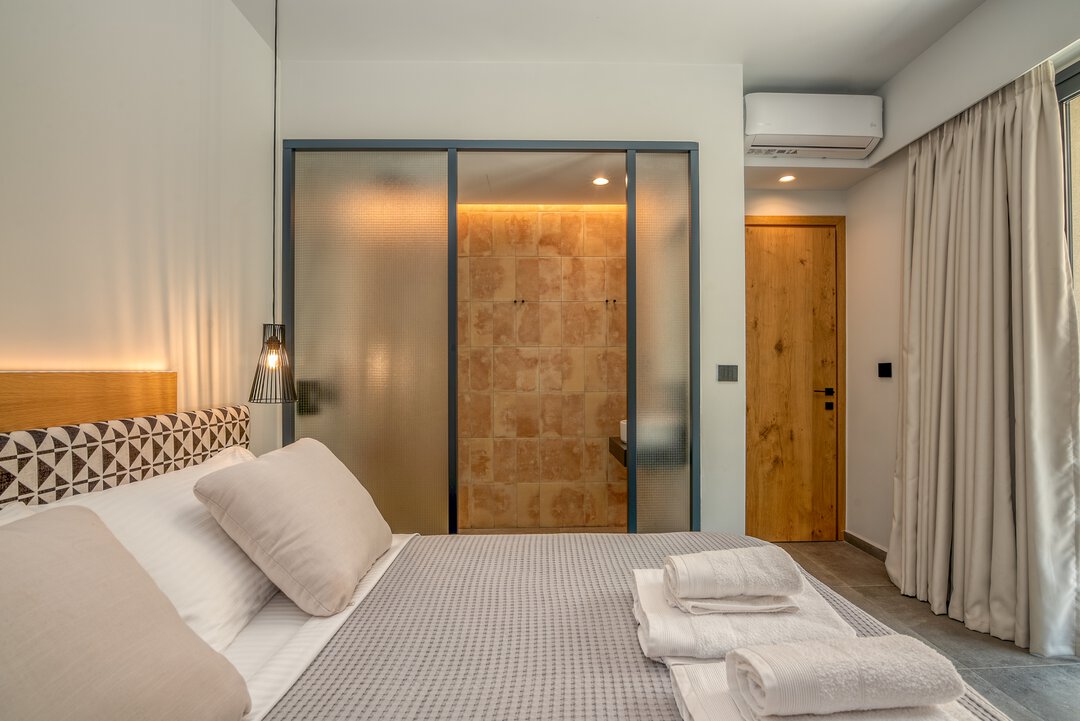 Luxurious bedroom featuring premium linens, ambient lighting strip, and designer furniture at Nusa Gramvousa villa near Balos, Crete