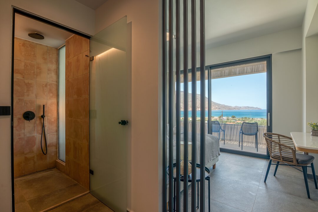 Spa-like bathroom with rainfall shower, terracotta and marble tiles, and ambient lighting at Nusa Gramvousa villa, Crete