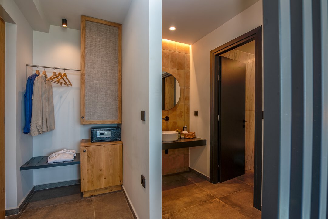 Designer walk-in shower with glass partition, dual shower heads, and warm tile palette at Nusa Gramvousa, Crete