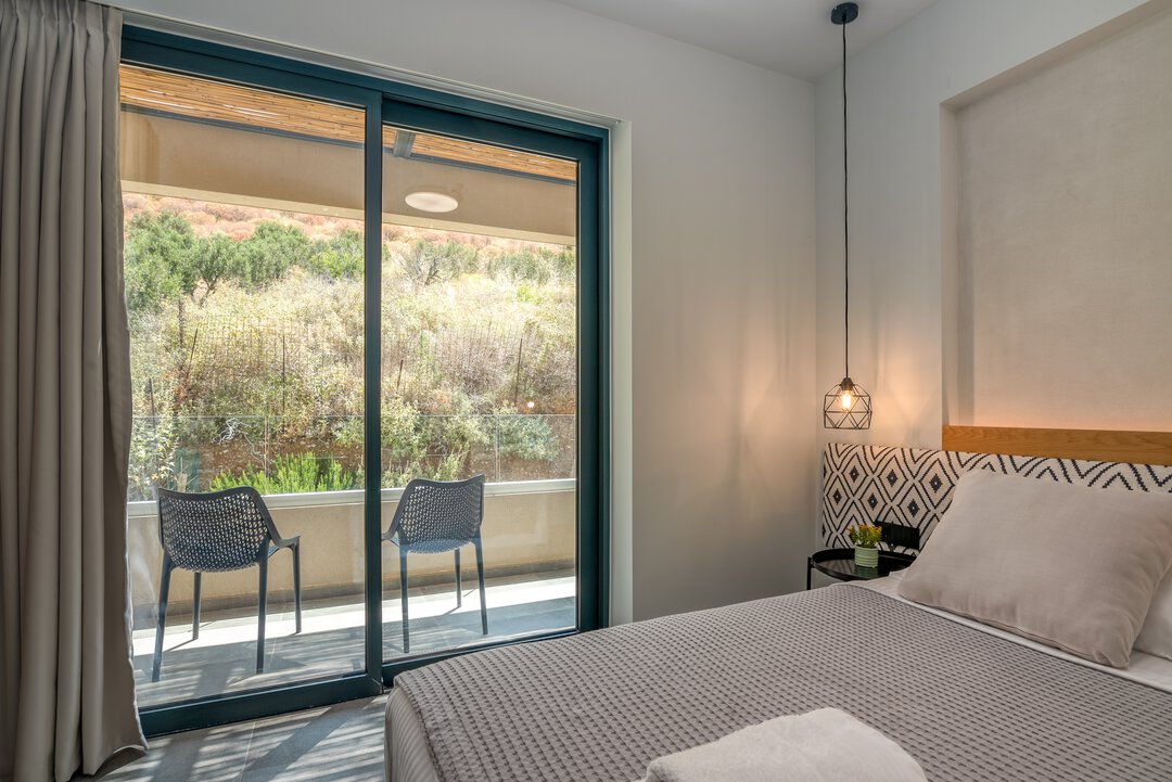Charming bedroom with textured bedding and wood accents at Nusa Balos, Crete